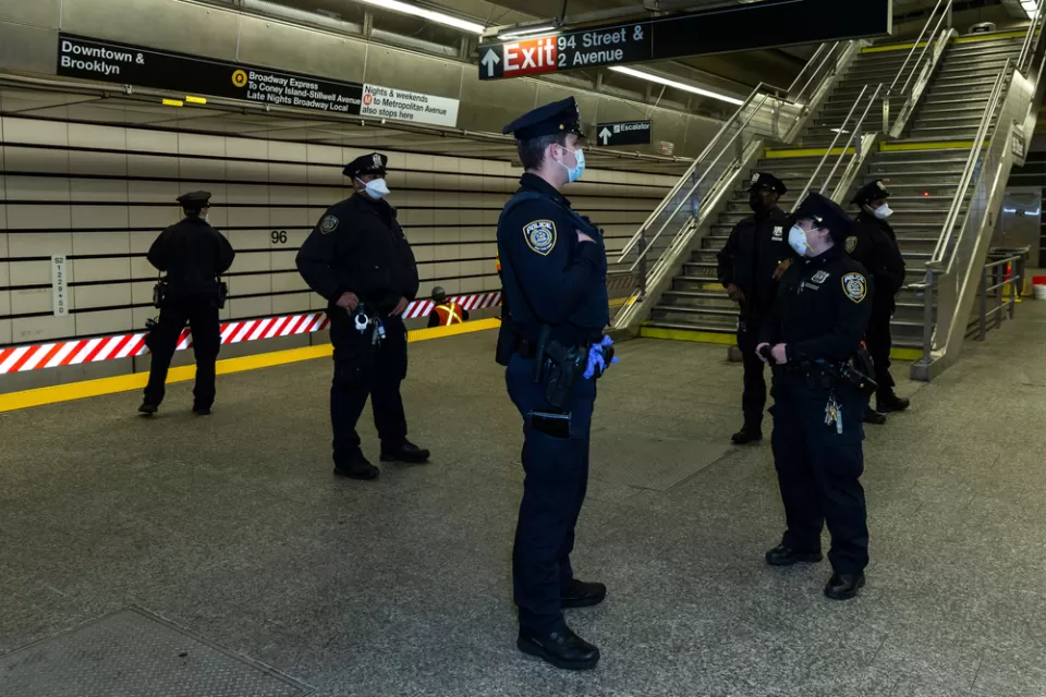 A group of police officers wearing masks during the Covid-19 pandemic gather on a subway platform in New York City.